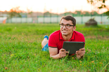 student with tablet pc in park on a sunny day