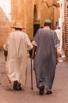 two traditionally clothed moroccans walking in the medina
