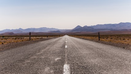 long straight road leading towards the mountains