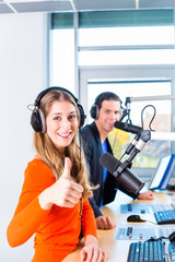Moderatoren in Radiostation - Mann und Frau - moderieren eine Sendung fürs Radio live im Studio