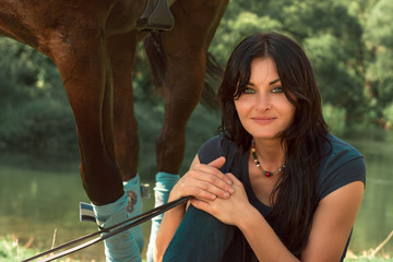 Portrait of a beautiful woman with a horse in the summer outdoors.