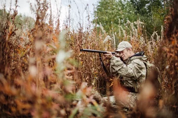 Fotobehang Jacht man jager met jachtgeweer in bos