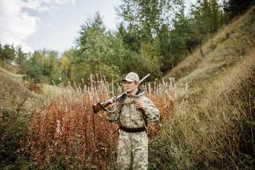 Fototapeta premium man hunter with shotgun in forest