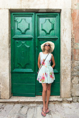 Attractive woman standing in front the rustic green door