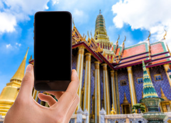 Naklejka premium Hand holding mobile with black screen on Thailand Temple background