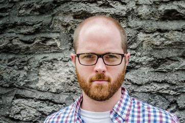 Close  up of Man with Glasses Against Stone Wall