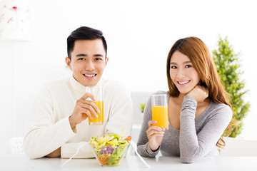 Young  smiling couple drinking juice and healthy food