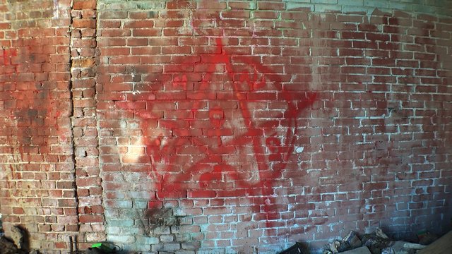 Pentagram, symbol of Satan on a brick wall. 4K.