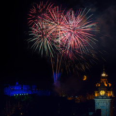Naklejka premium Edinburgh with fireworks over the castle and Balmoral clock tower