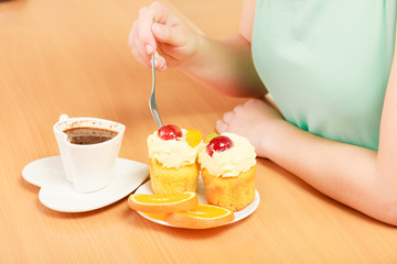Human hands with coffee and cake. Gluttony.