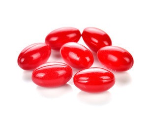 Red pill capsules on white background