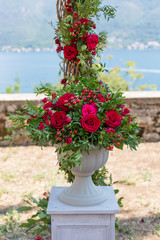 flower arrangement in stone bowl with red roses