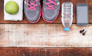 Sport shoes and water with set for sports activities on tiled floor.