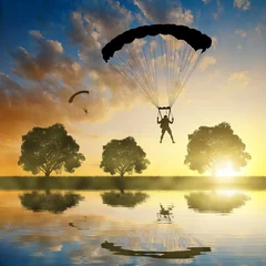 Photo sur Plexiglas Sports aériens Atterrissage de parachutiste de parachutiste de silhouette au coucher du soleil