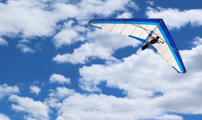 Hang Glider flying in Kitty Hawk North Carolina on a clear, bright, blue sunny day with clouds in...