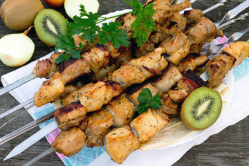 Pork with kiwi on the wooden table