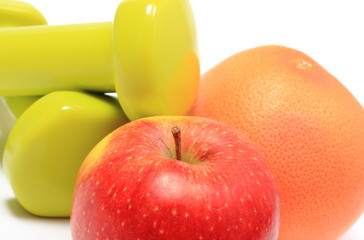 Apple and grapefruit with green dumbbells