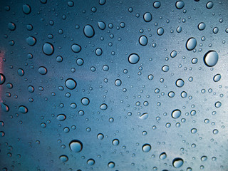 Water drops on glass on blue background
