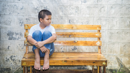 Young homeless Asian boy scared and alone, he is at high risk of being abused and trafficked