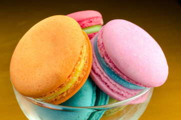 Colorful macaroons in a glass on wooden background, Selective focus