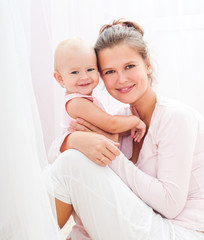 Mother and baby playing and smiling. Happy family.Home interior.