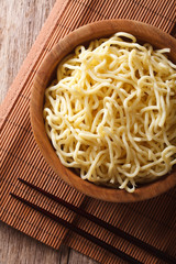Asian ramen noodles in wooden bowl close-up. vertical top view
