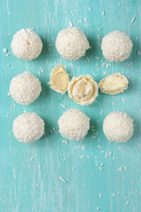 Coconut candies on aquamarine wood