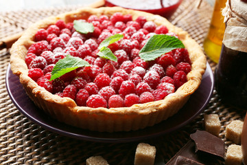 Tart with fresh raspberries, on wooden background
