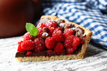 Piece of tart with fresh raspberries, on wooden background