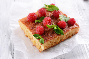 Fresh pie with raspberry on parchment on wooden table, closeup
