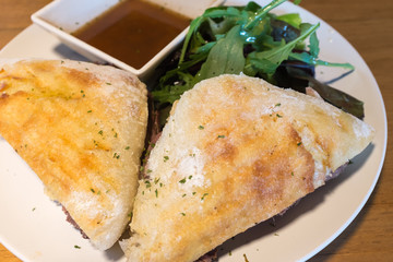 Roast beef sandwich dish with rocket salad