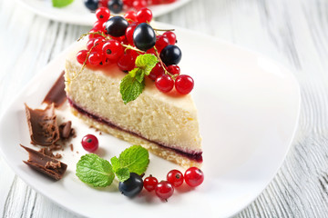 Delicious cheesecake with berries on table close up