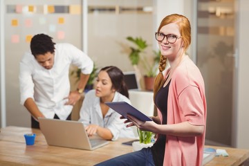 Portrait of businesswoman holding digital tablet in office