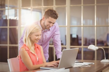 Smiling Business people looking at laptop