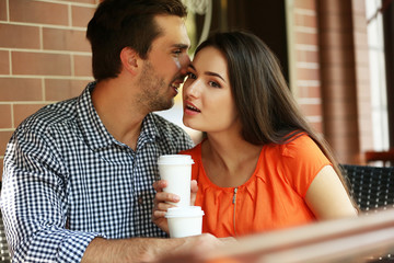 Young couple drink coffee in cafe outdoors