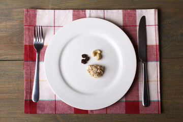fork and knife beside the plate of food on a napkin on wooden table