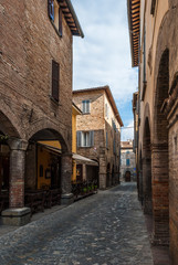 Fototapeta na wymiar Narrow street with cobbles in the small medieval town of Urbania (Marche region, Italy)