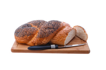 White bread, braided on a cutting board and table knife.