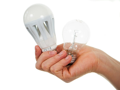Hand h&auml;lt LED-Lampe und Gl&uuml;hlampe