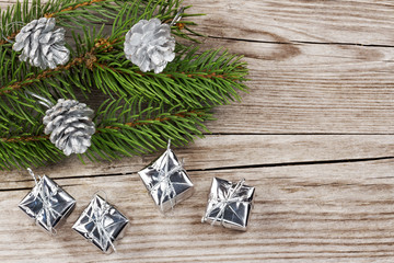 fir branch, silver fir cones and gift boxes on wood