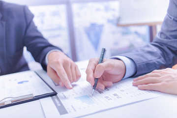 Fototapeta premium Two businessmen looking at report and having a discussion in off