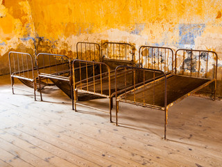 Old rusty beds in abandoned room