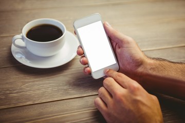 Person holding smartphone at the desk