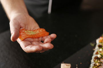 Etapy tworzenia sushi z surowym łososiem - obrazy, fototapety, plakaty