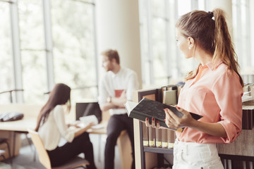 Beautiful woman reading a book in a library