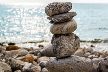 Fototapeta na wymiar Art of stone balance, piles of stones on the beach. Ibiza