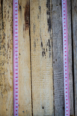 two tape measures in vertical line on old wooden background. Top view