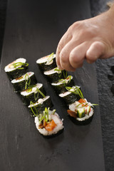 Sushi.Klasyczne  grube rolki futomaki podane na kamiennym talerzu