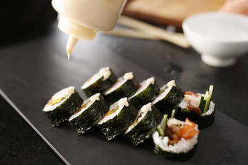 Restauracja japońska, sushi. Klasyczne  grube rolki futomaki podane na kamiennym talerzu