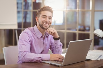 Portrait of businessman working on laptop